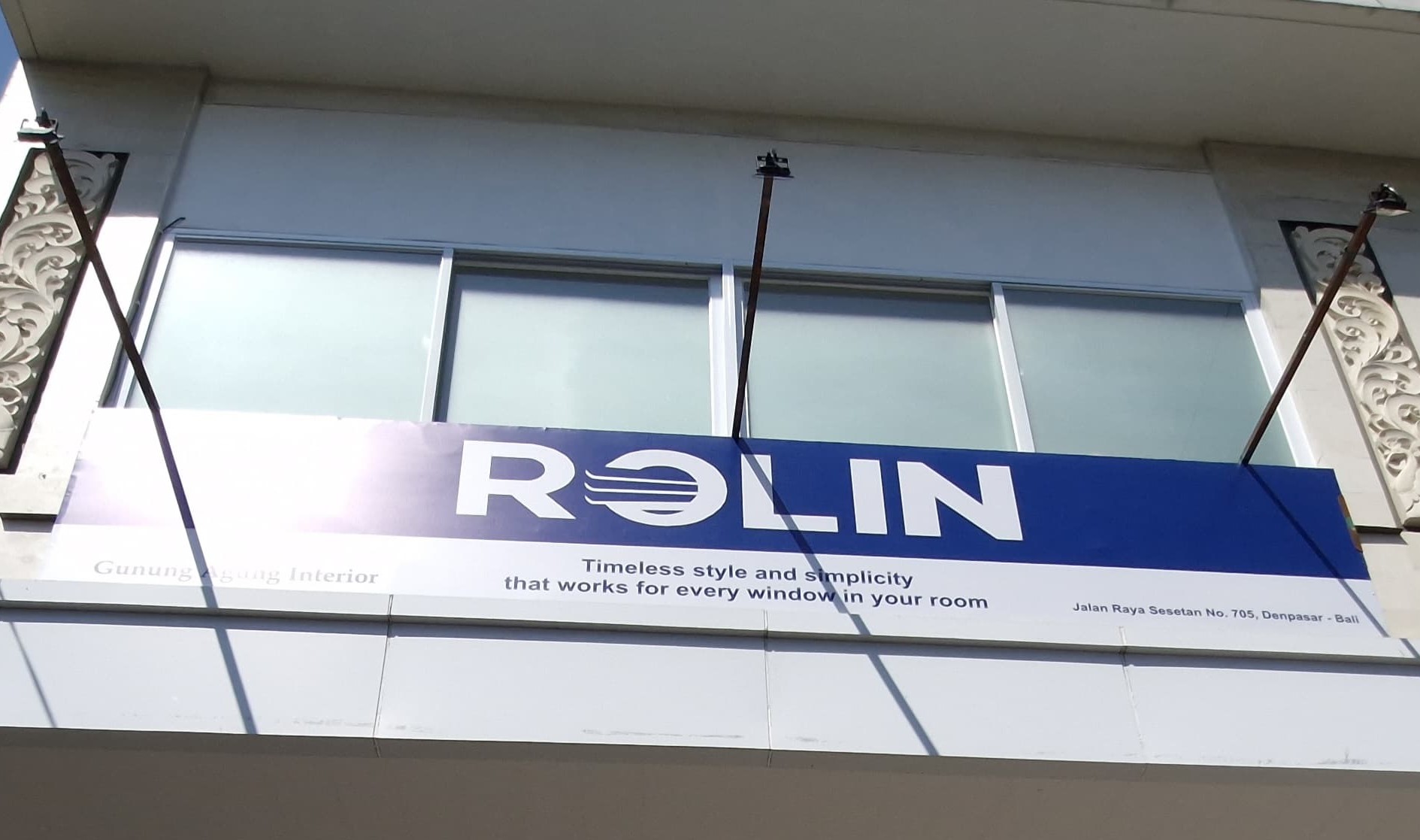 Modern interior room with roller blinds on large windows, soft natural light, and elegant furniture